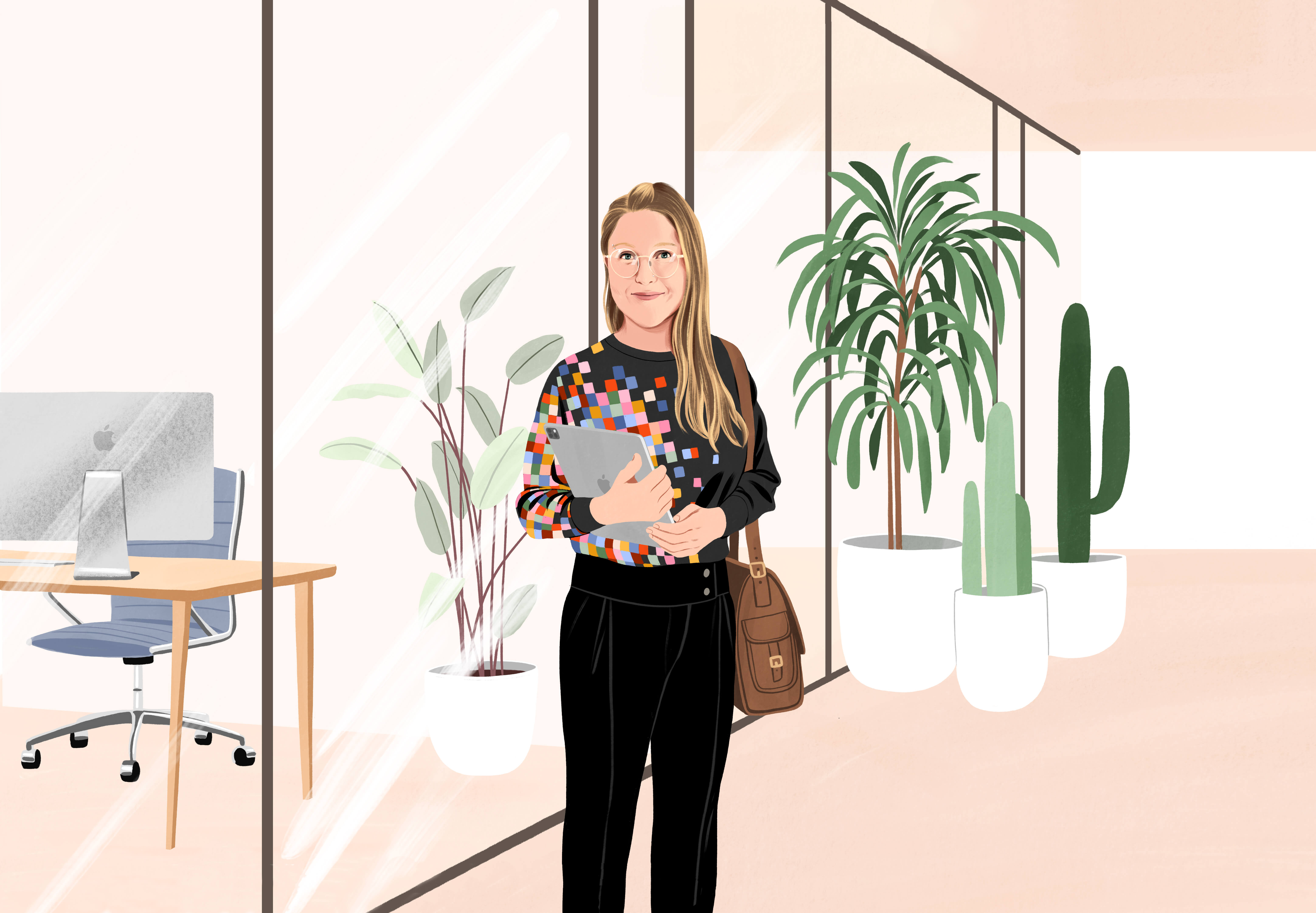 Manuela steht lächelnd in einem Büroflur, hält ein iPad in der Hand, eine Tasche hängt über ihrer Schulter. Sie trägt schwarze Hosen und ein schwarzes T-Shirt mit einem Pixelmuster in verschiedenen Farben auf einer Seite.