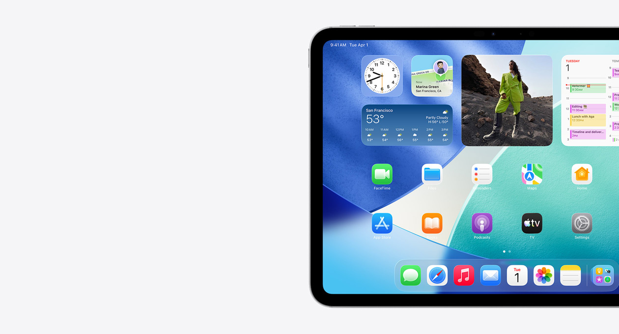 iPad, colocado na horizontal, com o lado esquerdo do ecrã a mostrar o ecrã principal com widgets empilhados, incluindo um relógio transparente com efeito Liquid Glass, app Encontrar, widget da app Meteorologia, duas filas de apps mais pequenas e Dock