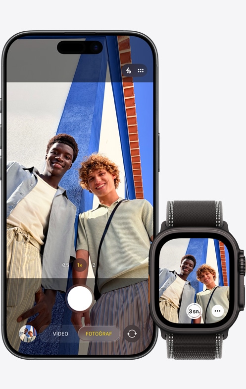 iPhone 17, önden dış görünüm, kamera grup selfie’si çekmek için kullanılıyor, Kamera Kumandası uygulamasının açık olduğu Apple Watch Ultra 3’ün yanında duruyor