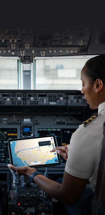 Una piloto en una cabina mira un mapa en la pantalla de un iPad.